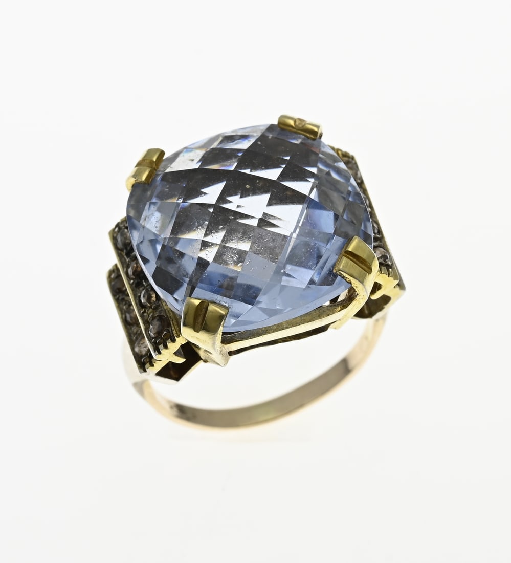 Ring with blue stone, 375/000: Beautiful large ring, 375/000, with a large blue facetted blue spinel set in a yellow setting. On the sides are 2 bars placed with 7 diamonds with an old cut and a brownish color. The ring has a
