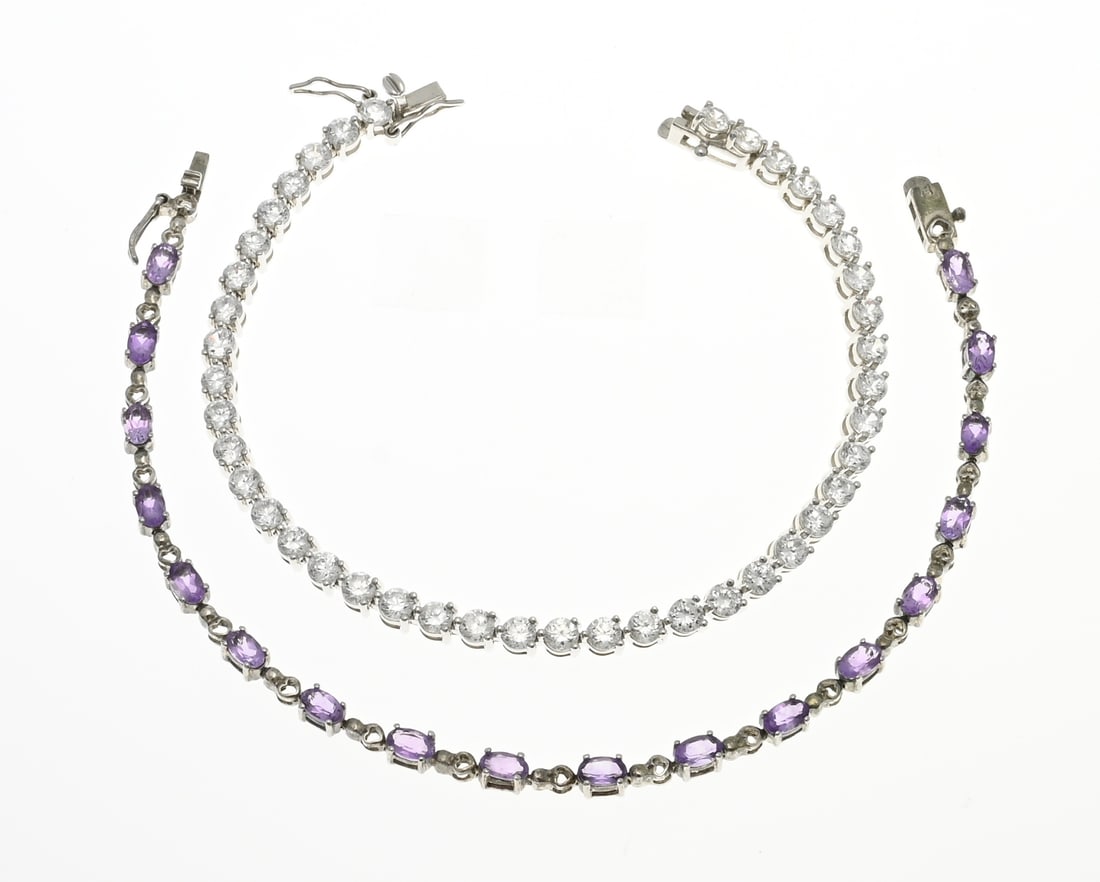 2 Silver bracelets with stones: Two silver bracelets, 925/000, with zirconias.; Tennis bracelet with zirconias, width 4 mm. And a bracelet with heart-shaped links and oval faceted purple stones. width 3.5 mm. Length 18-18.5 cm.