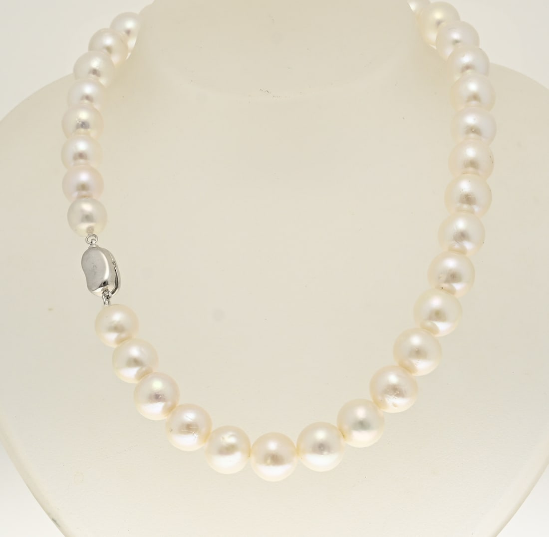 Pearl necklace: Necklace of large freshwater pearls, ø 11 mm. attached to a silver nugget-shaped clip closure. 925/000. Length 43 cm. New
