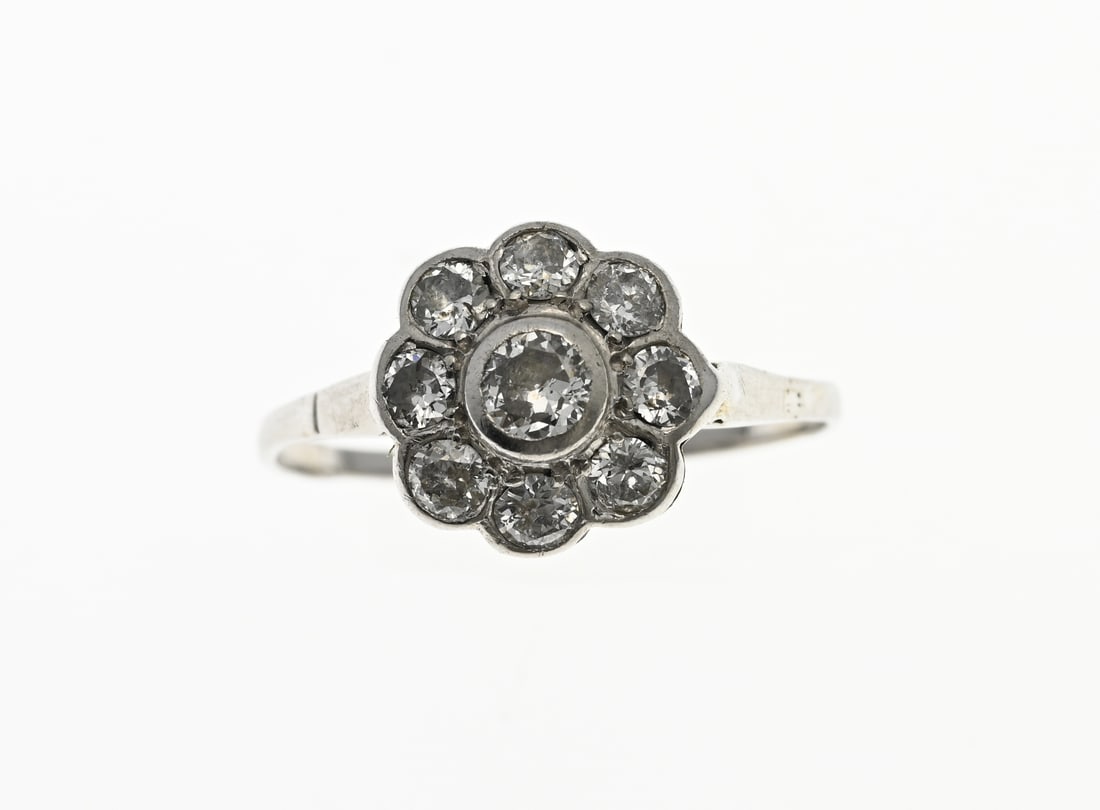 White gold rosette ring with diamond,: White gold rosette ring, 585/000, with diamond. Ring with a rosette in a smooth setting with a brilliant cut diamond in the middle, approx. 0.15 ct. And around it a rim with 8 brilliant cut diamonds,