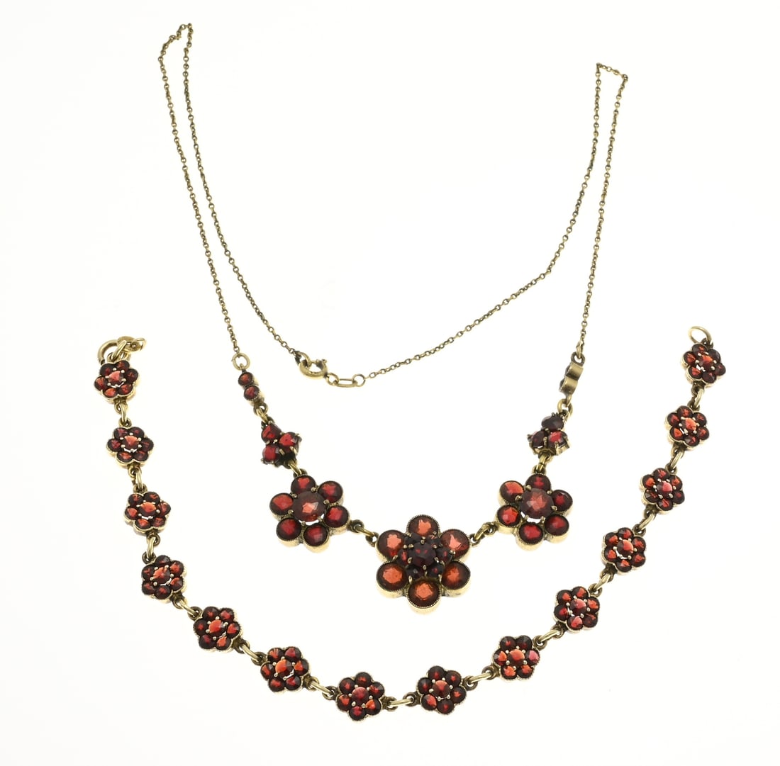 Choker and bracelet with garnet, flowers: Silver plated bracelet and a double choker with flower elements set with garnet stones. Width bracelet 8 mm. Length 20 cm. And a choker with anchor necklace with in the middle a various flower