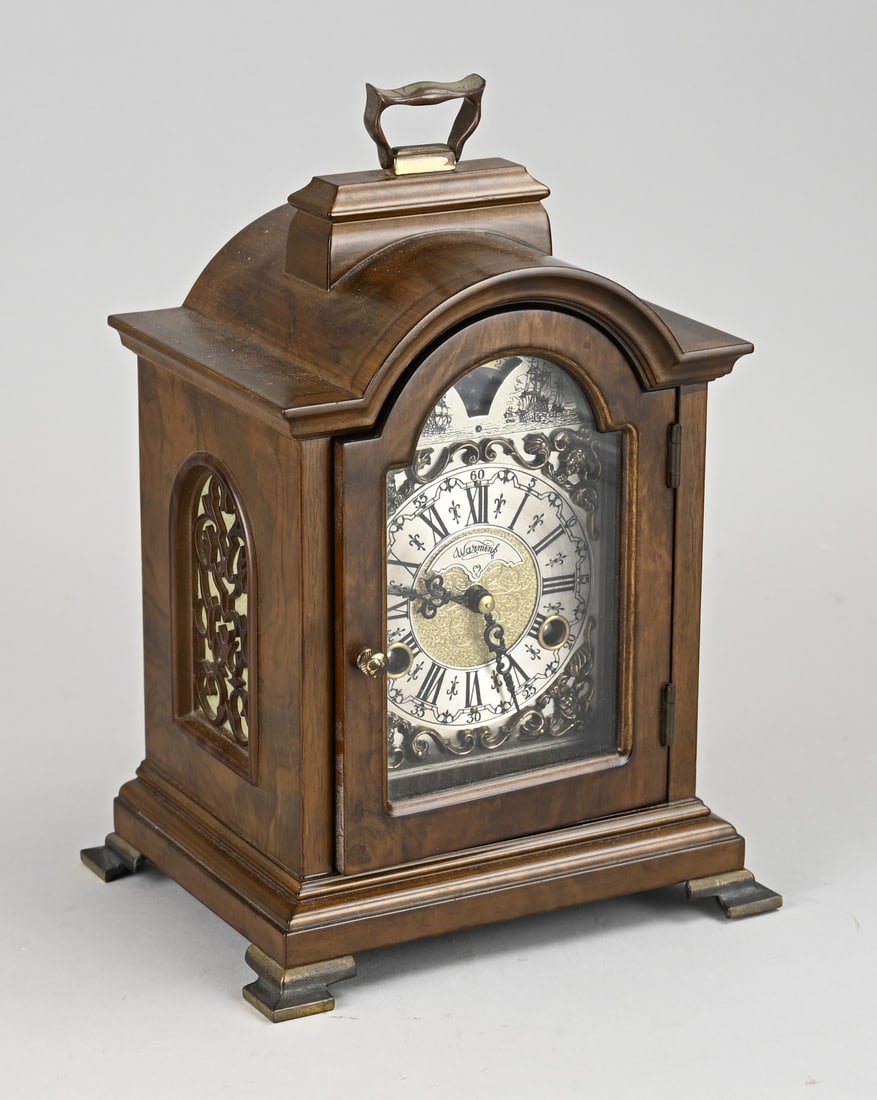 Walnut table clock, H 29 cm.: Warmink walnut table clock with half-hour chime and moon phase. Second half of the 20th century. Dimensions: H 29 cm. In good condition.
