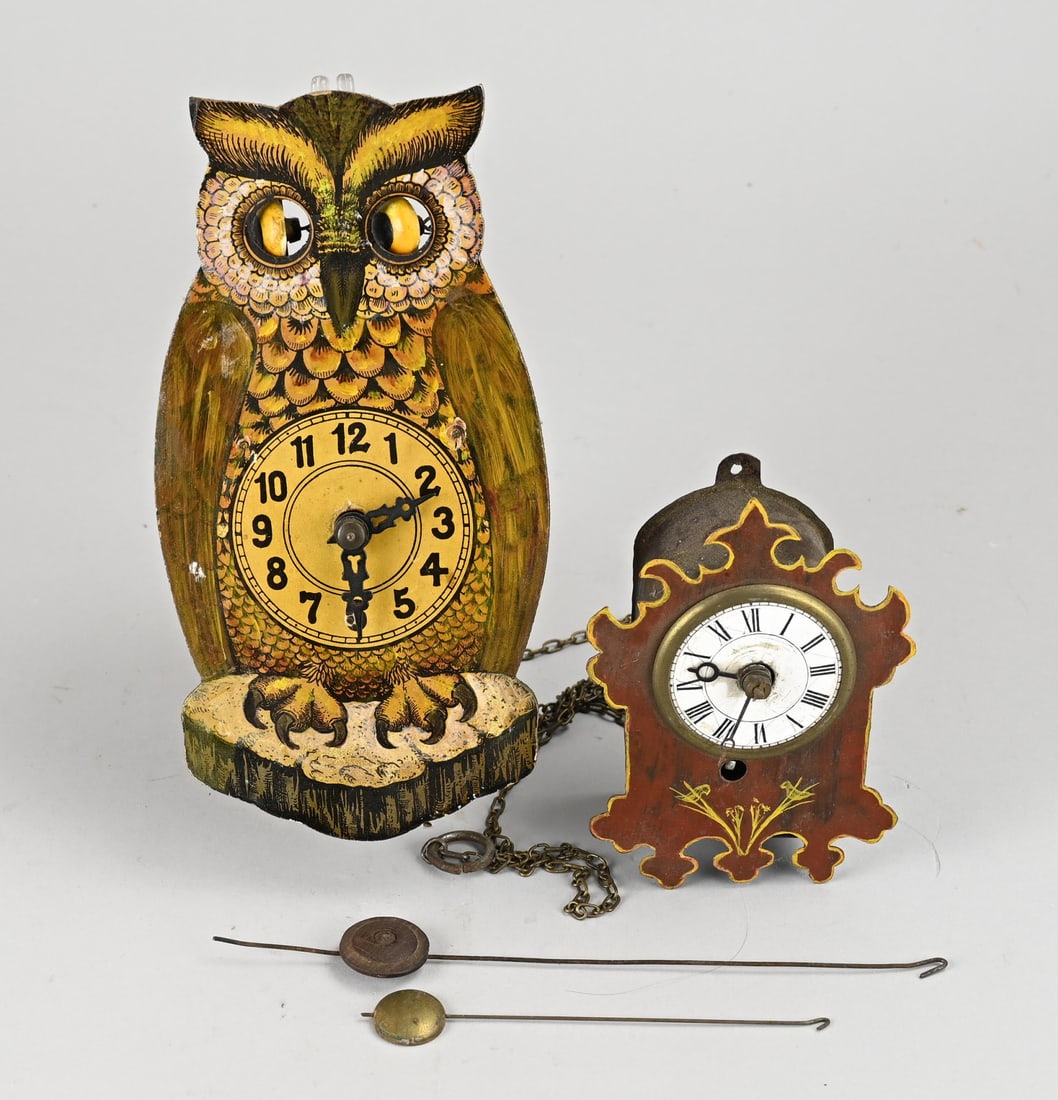 2x Miniature clock, 12 - 19 cm.: Two antique miniature clocks. Germany. Circa 1900. 1x Black Forest Augenwernder owl (Uhren Fabrik Herr). 1x tin wall clock. Size: 12 - 19 cm. In good condition.