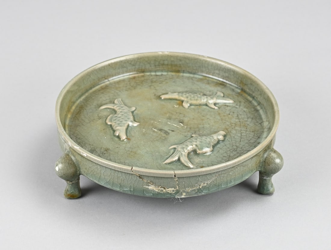 Chinese water holder Ø 17.6 cm.: Old Chinese porcelain celadon water bowl with a relief carp design. Two legs have been restored. Dimensions: Ø 17.6 cm. In fair to good condition.
