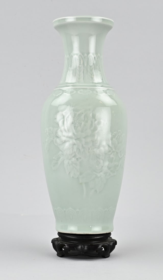Chinese vase on wooden base: Chinese porcelain celadon vase with relief peony decoration. 20th century. Dimensions: H 30 cm. In good condition.