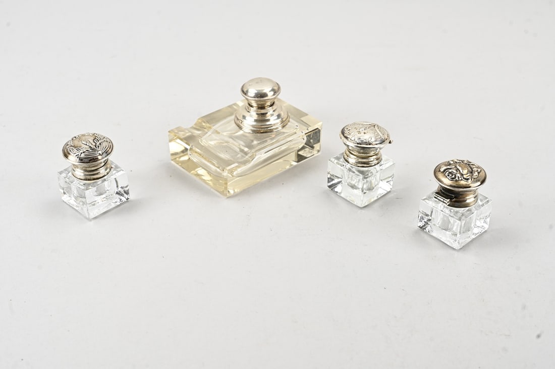 4 Inkwells with silver: Four crystal inkwells with silver, 3 square inkwells fitted with a round silver lid with a collar, 925/000, decorated with floral motif. One features an engraving on the inside of the lid: Cock 2-3-06