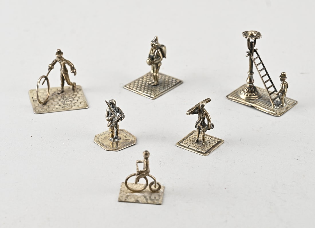 6 Silver miniatures: Lot of 6 silver miniatures, 835/000, featuring a carpenter, a lamplighter, a scribe, a figure on a bicycle, a figure with a hoop, and a liquor vendor. Total approx. 60 grams. 3-4.5cm. Maker: including