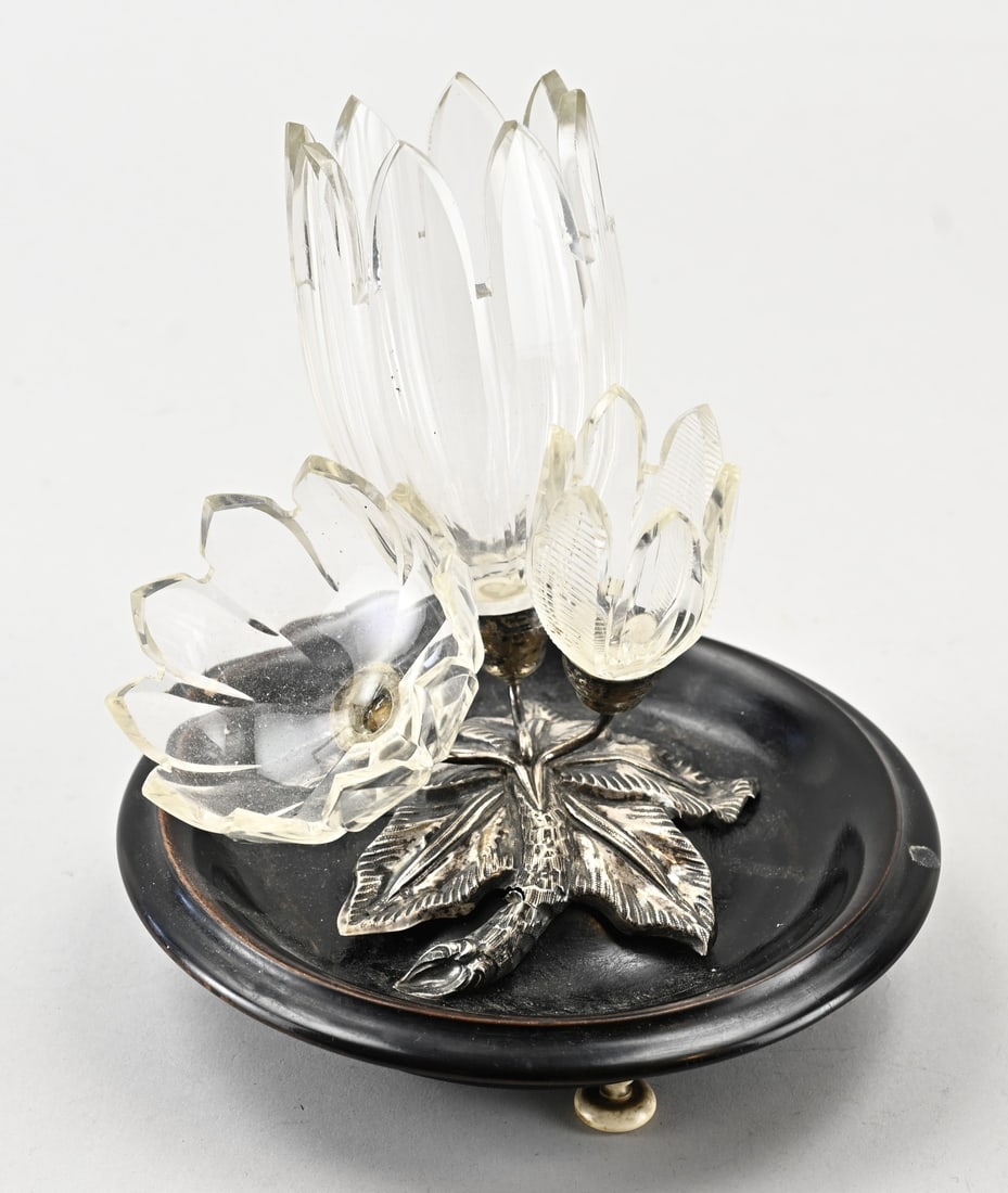 Table set, crystal with silver: Antique cut crystal three-piece table set in a floral silver leaf-shaped mount, 833/000. The set is placed on a round black mahogany plateau with legs. MT.: J. Held, Amsterdam. jl: P: 1874.