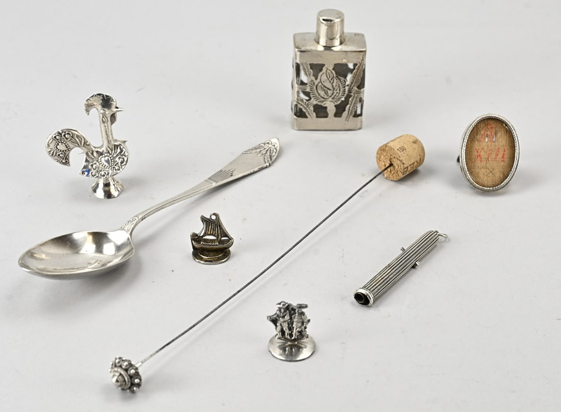 Lot of various silver: Lot of silver with a spoon, a small oval photo frame, a crystal flask with silver overlay, a miniature rooster, a candle snuffer with figures and a stamp with a ship, a hat pin with a silver button, a
