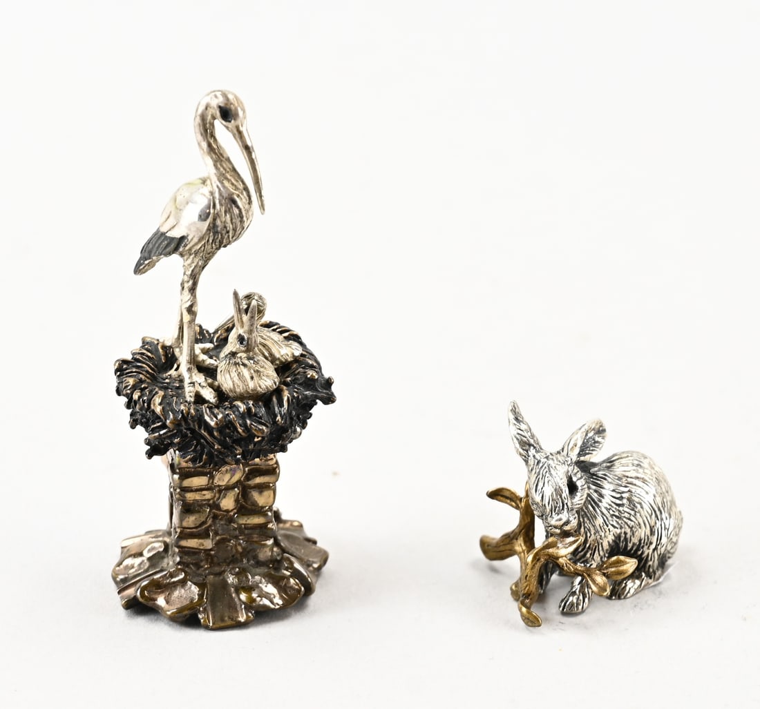 2 Silver figurines: Two silver figurines, a rabbit, 800/000, with a branch. MT.: Pietro Sorini & Ilarsio Casi, Arezzo. And a bronze figurine in the shape of a stork with young on a mantelpiece. MT.: Vittorio Ancini & Pie
