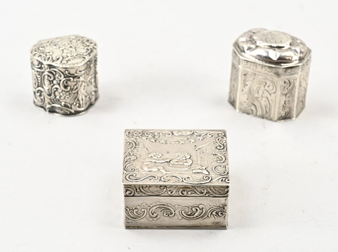 3 Silver boxes: Lot of 3 small silver boxes: a square box with a hinged lid featuring an image of putti, MT.: H.Hooijkaas, Schoonhoven, 1904. An octagonal box decorated with engraving, MT.: unclear, Schoonhoven, 1858