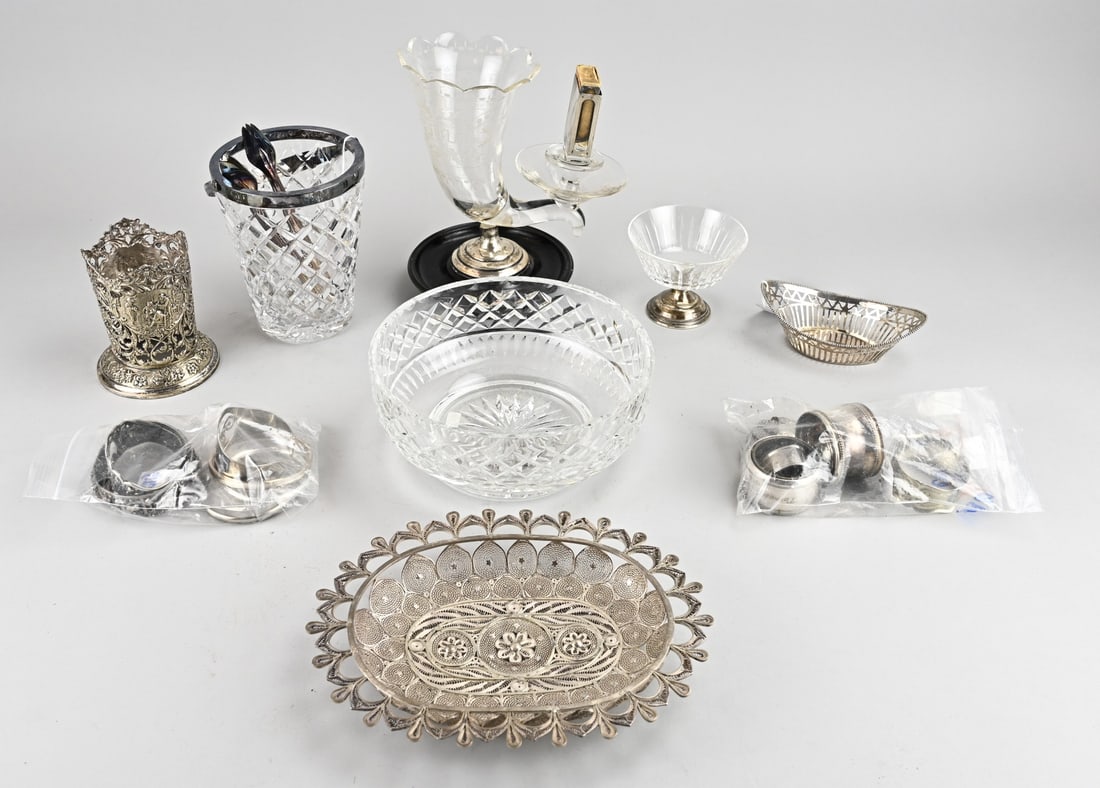 Lot of crystal with silver and plated, miscellaneous: Large lot including a plated bonbon basket, filigree dish, holder with figures, crystal ice bucket with plated rim, cigarette holder on a silver base, and silver match holder. Various plated napkin ri