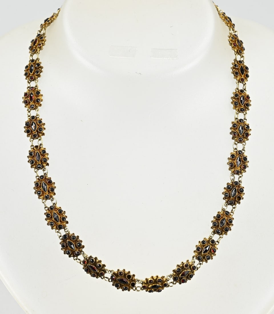 Gold boat necklace with garnet.: Yellow gold boat necklace, 585/000, with garnet. Necklace made of oval links set with 7 garnet stones. Fitted with a box clasp. Width 10 mm. Weight 16.6 grams. Length 42 cm. In good condition.