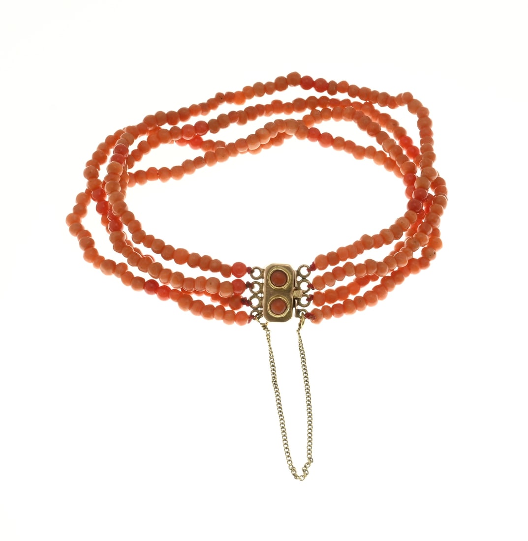 Bracelet with blood coral and gold clasp: Bracelet of 4 rows of red coral, ø 3 mm., attached to a yellow gold clasp, rectangular model with red coral and a safety catch. Length 18 cm. approx. 10.6 grams. In good condition.