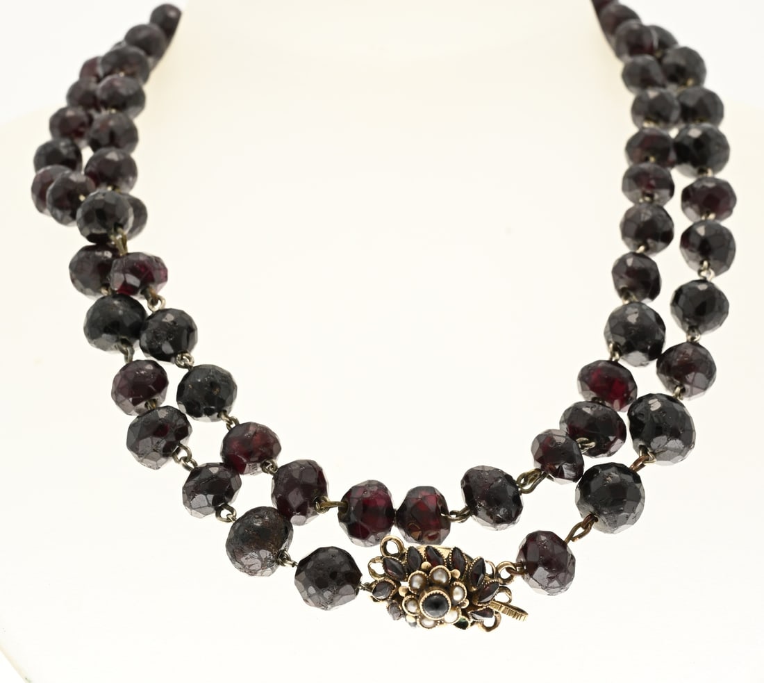 Long garnet necklace with gold clasp: Long necklace of faceted garnets strung on metal wire and attached to a yellow gold clasp, 585/000, with garnets and pearls. 1 garnet is missing. Clasp approx. 3.2 grams. Approx. 85 cm. In good condit