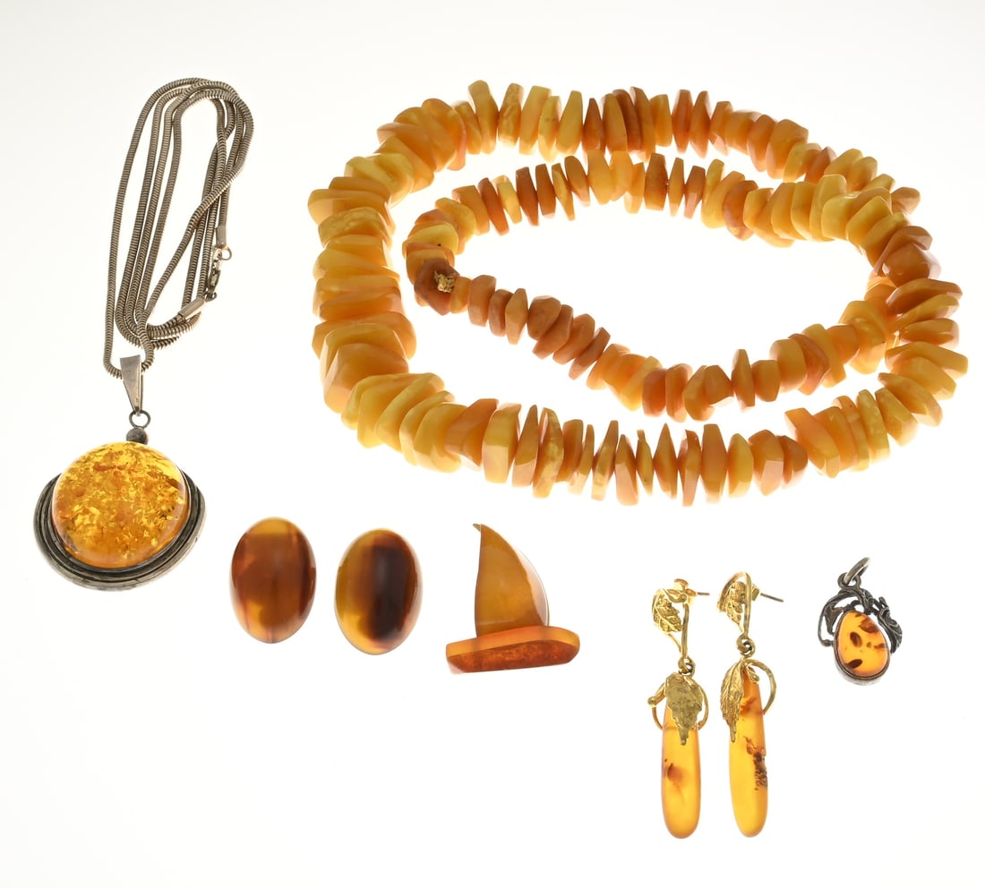 Lot of jewelry including amber/copal: Lot of amber jewelry, silver necklace with a pendant set with amber, a pair of double dangle earrings and clip-on earrings with amber. A boat-shaped amber brooch and a necklace with opaque amber beads