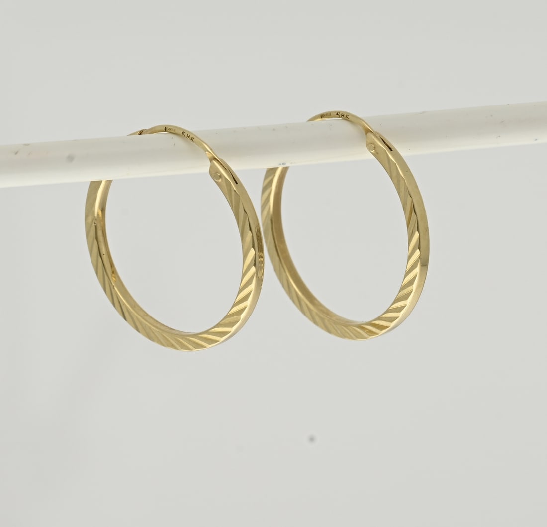 Gold hoop earrings with embellishment: Yellow gold hoop earrings, 585/000, made from square tubing with a cut line decoration. Fitted with a hinged post. Width 1.4 mm. Approx. 1.0 gram. ø 18 mm. In good condition.