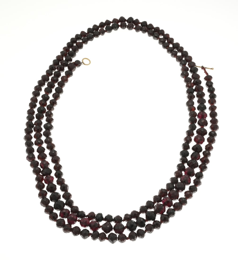 Garnet necklace with gold: Long necklace of garnet beads, ø 6-8mm, knotted and attached to a gold toggle bar and loop. Length 135 cm. Total approx. 101.6 grams. In good condition.
