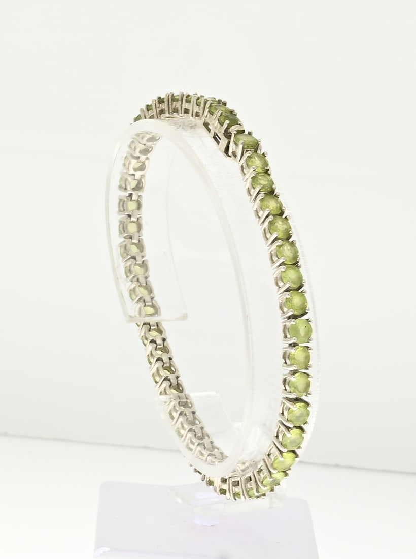 Silver bracelet with green stones: Silver tennis bracelet, 925/000, with light green stones. Width 4 mm. Length 19 cm. Approx. 13.9 grams. In good condition.