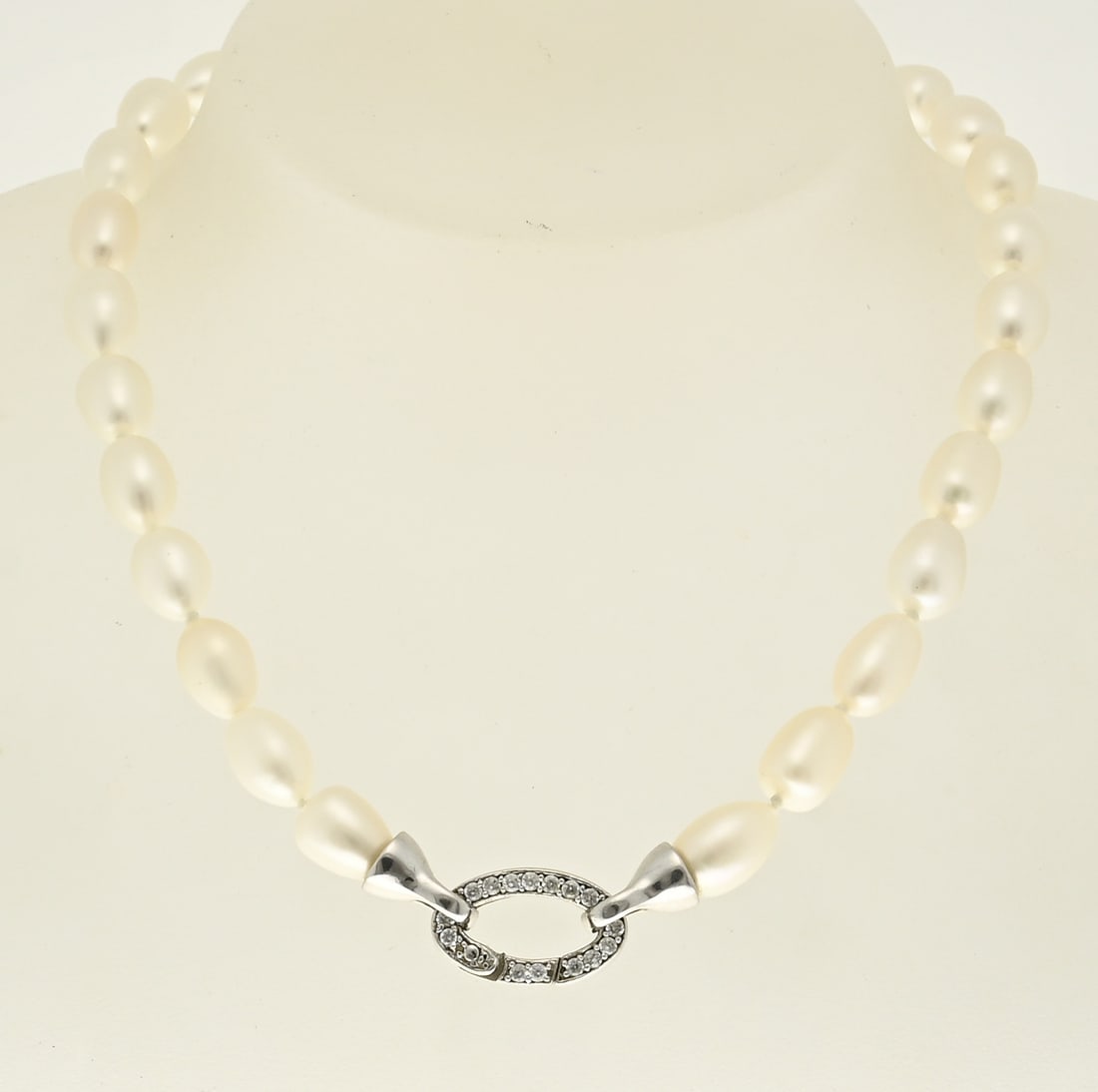 Pearl necklace: Necklace of oval freshwater pearls, 7.5x11mm, attached to an oval silver clasp, 925/000, with cubic zirconia. Length 51 cm. In very good condition.