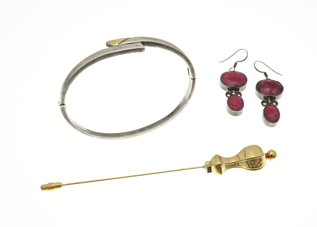 Lot with 3 pieces of jewelry: Lot of three pieces of jewelry including a pair of silver earrings with rubies, a silver bangle, matte finished with a rectangular band and gold plating on the top. And a double brooch. In very good c