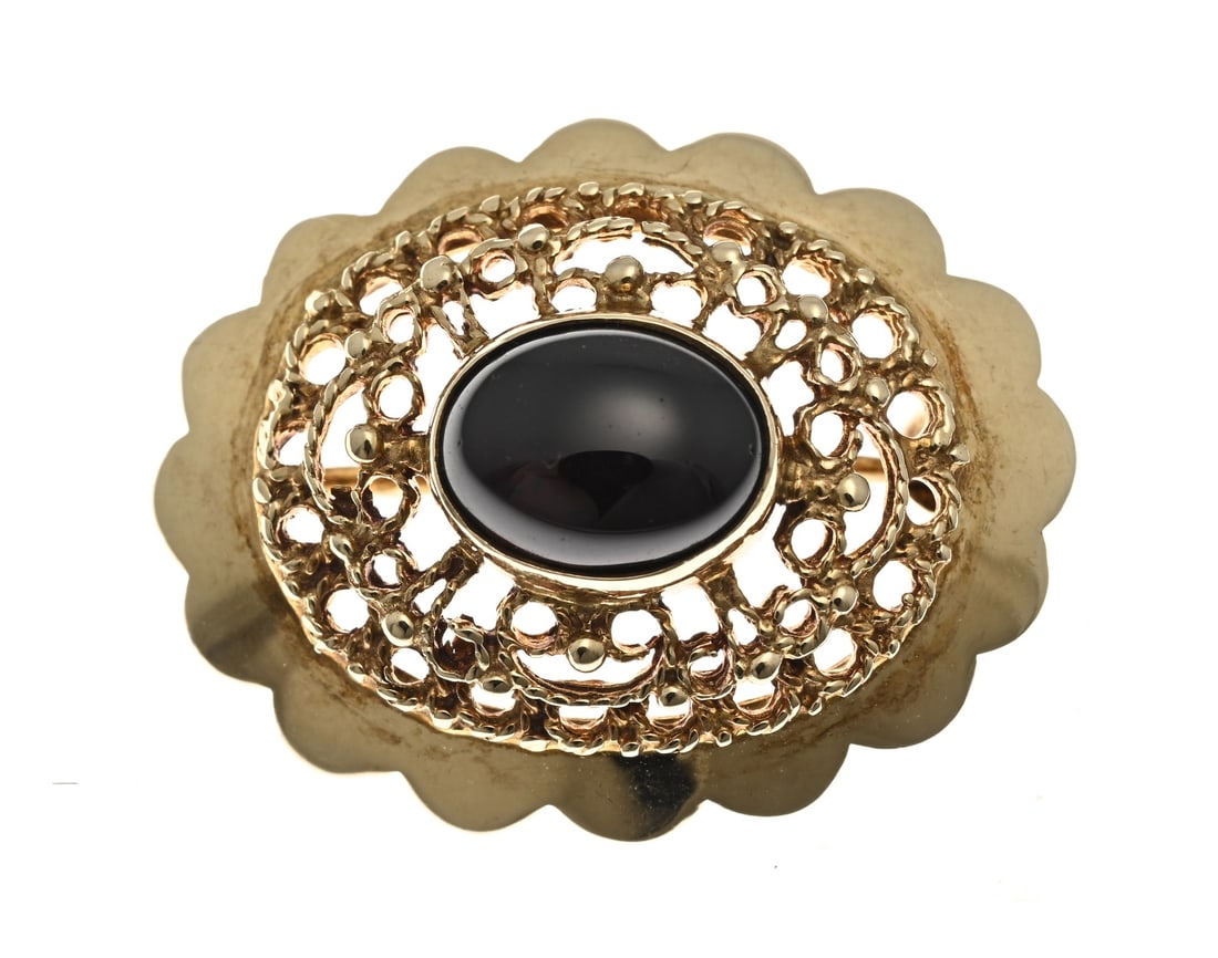 Gold brooch with garnet: Yellow gold brooch, 585/000, with garnet. Oval-contoured brooch, openwork with a cabochon-cut garnet stone in the center. 20x25mm. Approx. 4 grams. In good condition.