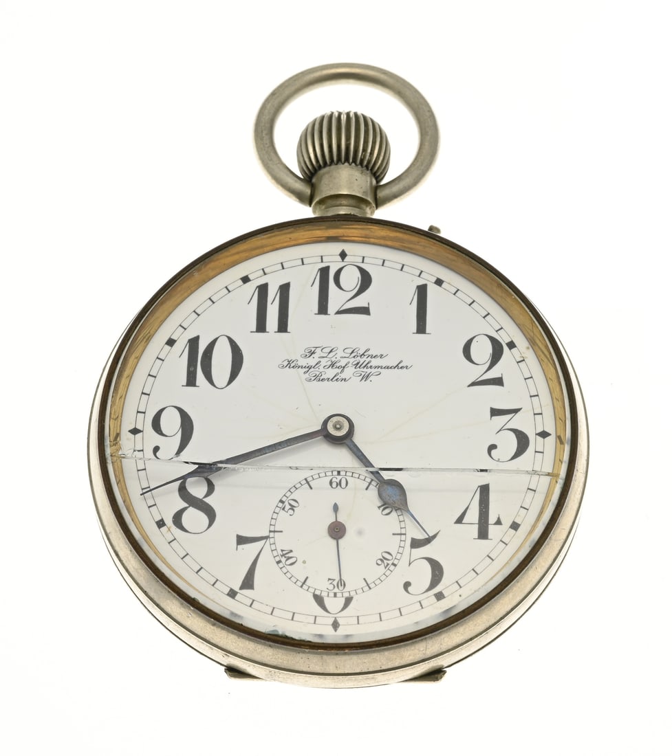 Large pocket watch: Large pocket watch FLLöbner, Köningl. Hof-Uhrmacher Berlin W, with a white enamel dial featuring Arabic numerals. Mechanical. Working. Crack in glass. ø 65 mm. In good condition.