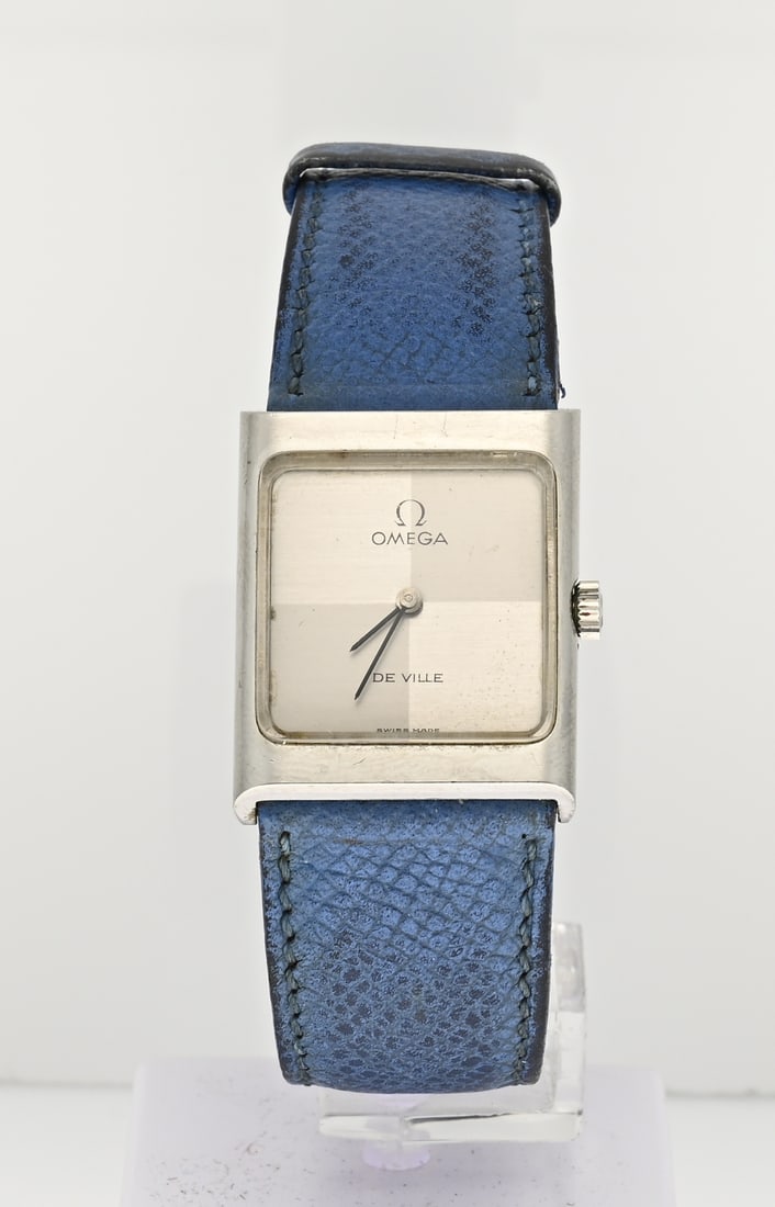 Omega watch blue strap: Omega de Ville, Lady, steel model, mechanical, featuring a rectangular case with a dial featuring a matte and glossy finish. The watch has a light blue strap. Width 23 mm. Working. In good condition.