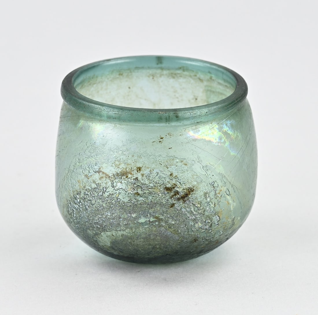Roman glass Ø 8 cm.: Antique Roman glass with oxidation (green, blue, yellow, etc.). Archaeological find. Dimensions: H 7 x Ø 8 cm. In good condition.
