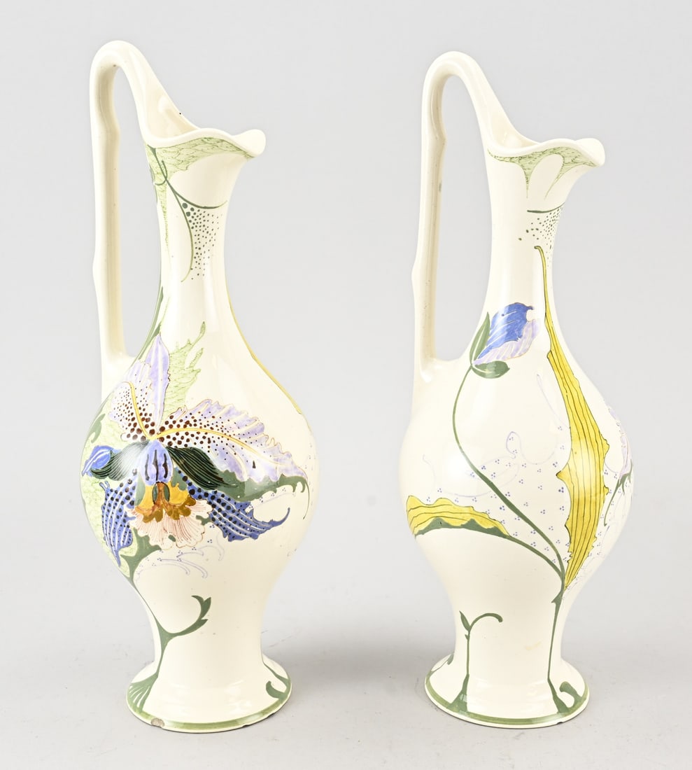 2x Gouda earthenware jug, H 35 cm.: Two Dutch polychrome Gouda earthenware pitchers with floral decoration. Art Nouveau. Circa 1900. Dimensions: H 35 cm. Both pitchers have chips on the bottom.