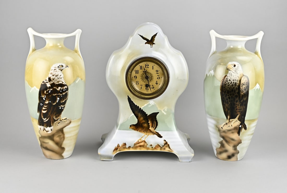 Antique clock set, 1900: Antique Petrus Regout Maastricht clock set with bird of prey decoration. Circa 1900. Art Nouveau. Dimensions: 38 x 39 cm. In good condition.