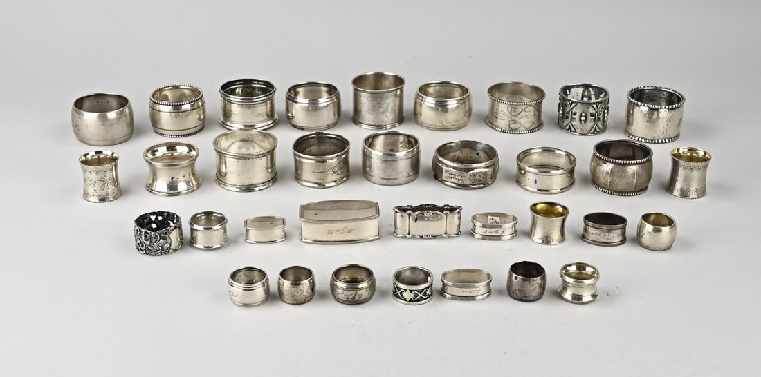 Large lot of napkin rings: Large lot of silver napkin and finger towel bands, various models and finishes. Some feature engravings. Various finenesses. Total approx. 670 grams. In reasonably good condition.