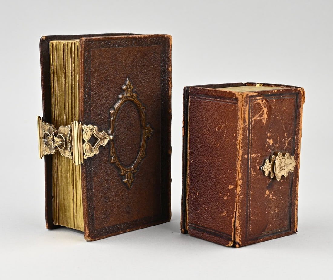 2 Antique Bibles with goldwork: Two antique Bibles with yellow gold clasps, 585/000. A small Bible, the New Testament, with a brown cover, torn, and a gold contoured clasp decorated with engraving, and a Bible, the New Testament,