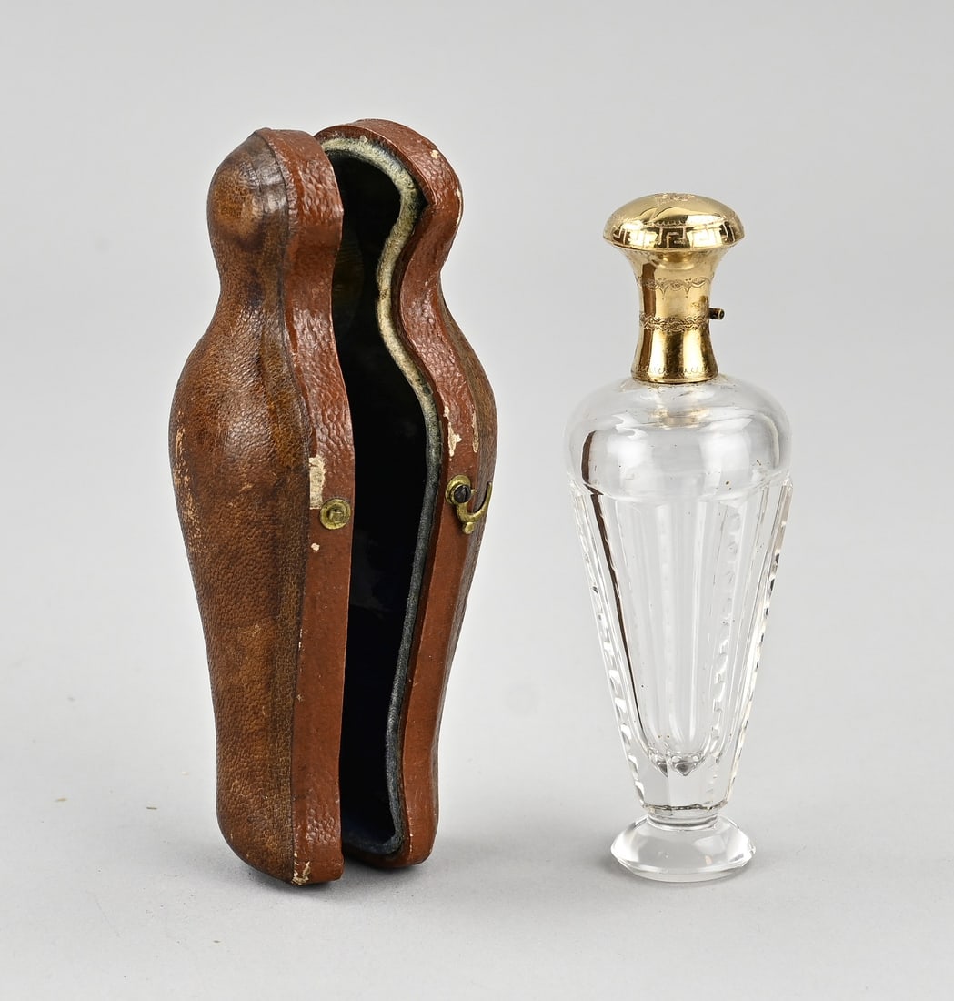 Fragrance bottle with gold in a case: Case filled with a crystal perfume bottle with a yellow gold collar and cap, 585/000, decorated with engraving. 10 cm. In good condition.