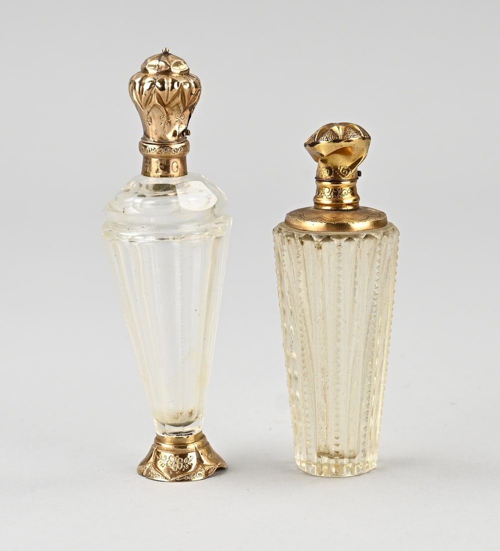 2 perfume bottles with gold: Two crystal perfume bottles with gold, 585/000. Cut bottle with a round collar and cap decorated with engraving, dented. With inner stopper. 9 cm. And a crystal bottle on a round gold base with a