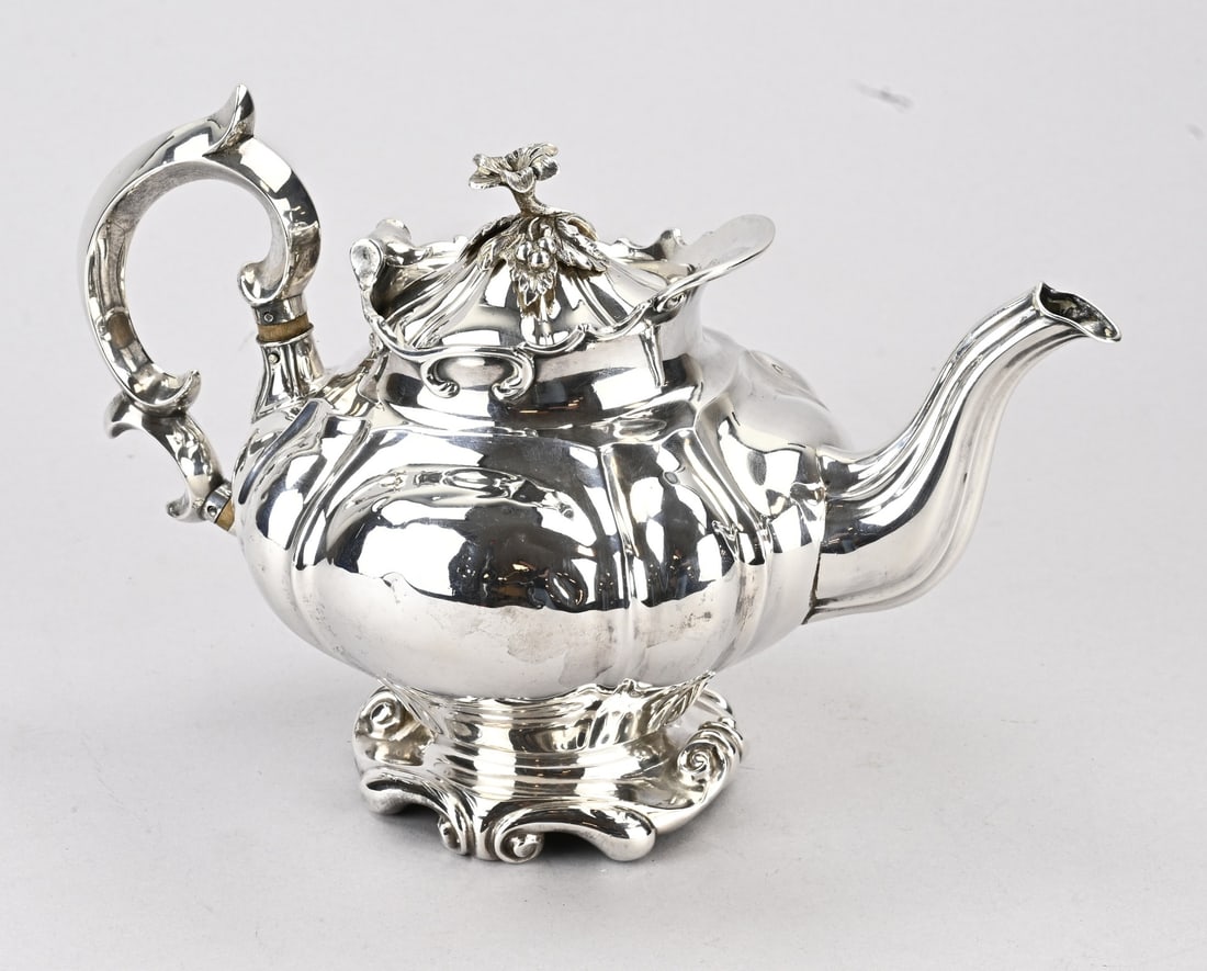 Silver teapot: Silver teapot, 934/000, contoured model on a foot with curls and ribs. Fitted with a lid featuring a floral element. MT.: JDArnoldus & JWWiellick, Amsterdam. jl.:N:1847. 23x16x18cm. approx. 521