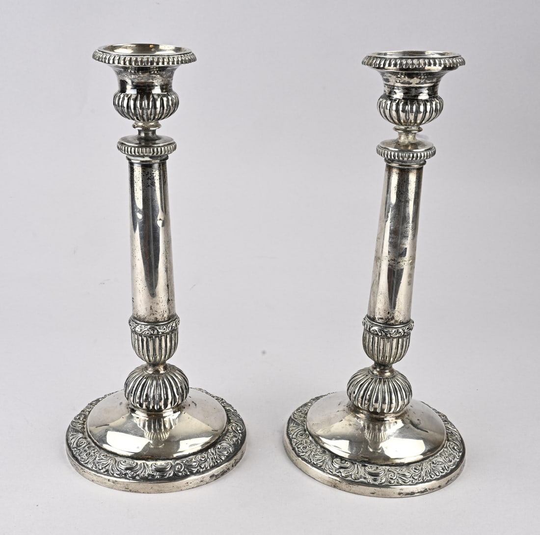 2 Silver candlesticks: Two fine silver table candlesticks, 800/000, on a round base with a floral rim, decorated column, and a light with ribbing and a scalloped edge. ø 14x30cm. Total approx. 798 grams. MT.: H in star