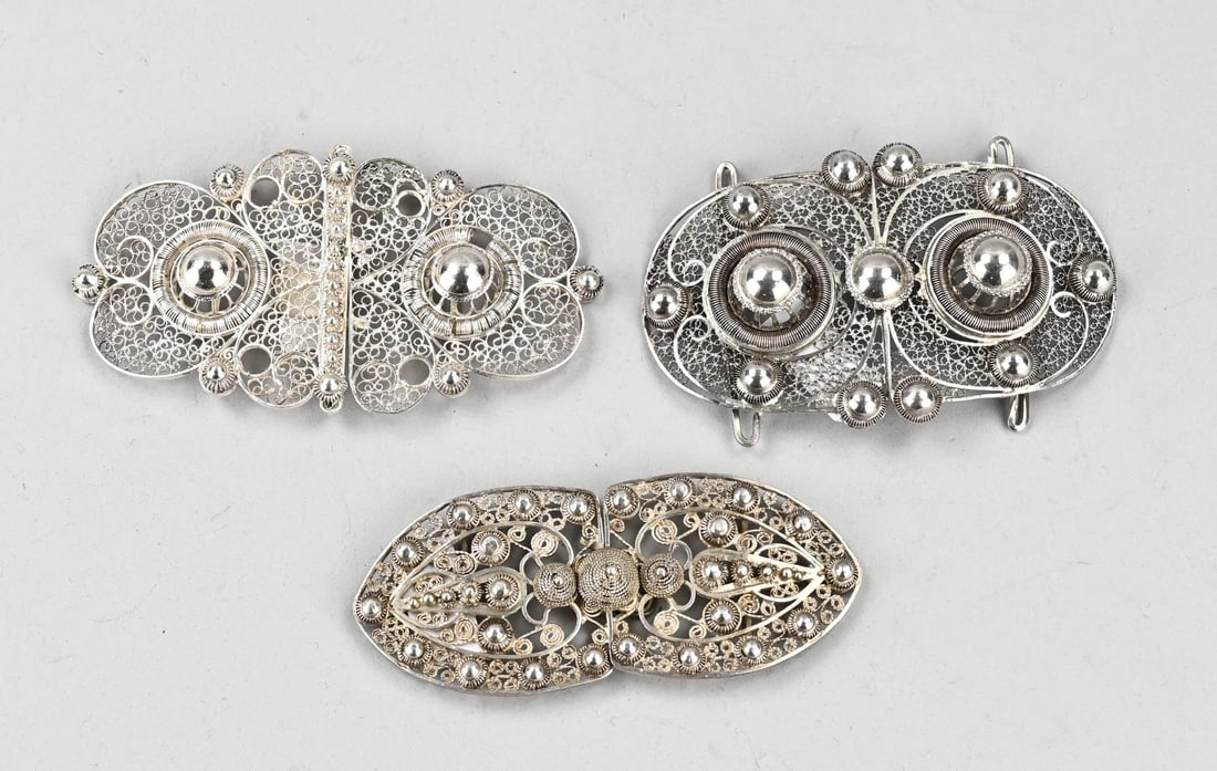 3 Silver belt buckles: Three silver belt buckles, 833/000, contoured model with filigree decorated with knobs. Total approx. 95 grams. Restoration. Otherwise in good condition.