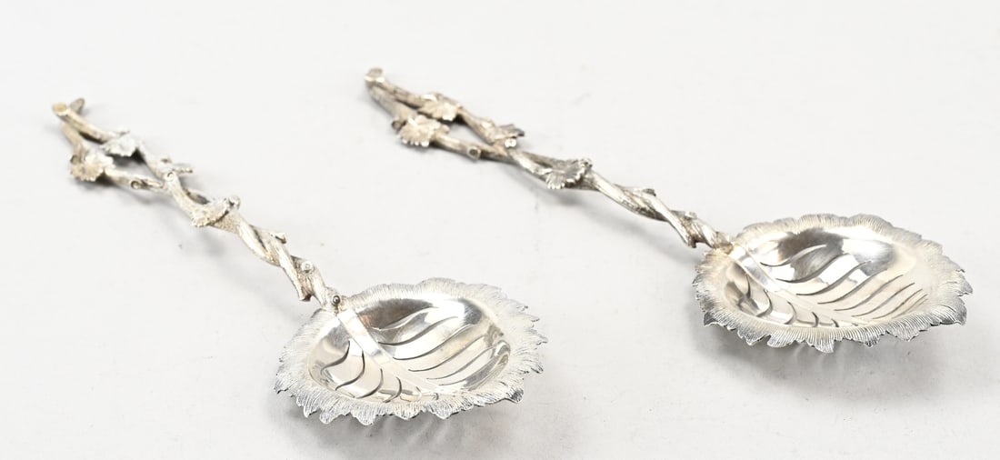 2 Silver wine spoons: Set of silver fruit wine spoons, 833/000, with a leaf-shaped scoop with serrated veins and an ornate rim. Attached to the scoop is a handle in the shape of a grapevine with a leaf. MT.: HW van Riel,