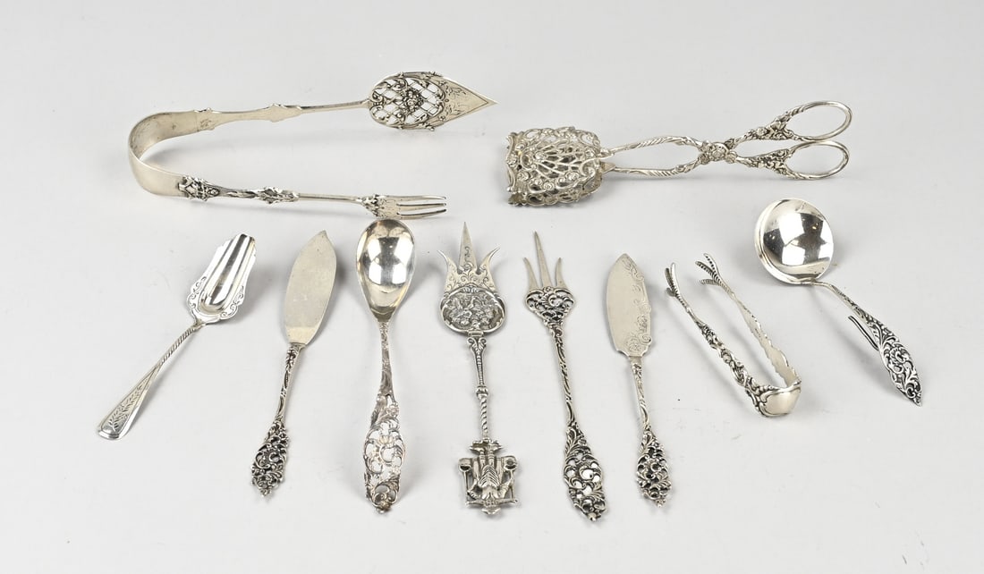 Lot with various silver cutlery pieces: Lot of various silver cutlery pieces with Biedermeier decoration, 833/000. Including a petit four server, cream spoons, and cake fork. Maker: among others BWEldick, Zutphen and Zaanlandse