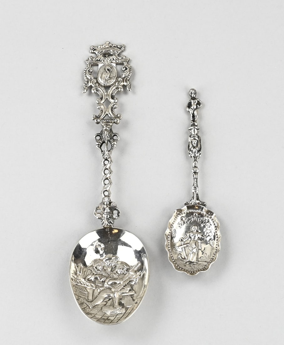 2 Silver commemorative spoons: Two silver commemorative spoons, 835/000, a small chased commemorative spoon with fancy hallmarks in the bowl and an image of De Hoop under a laurel branch, handle with angel and wings and a standing