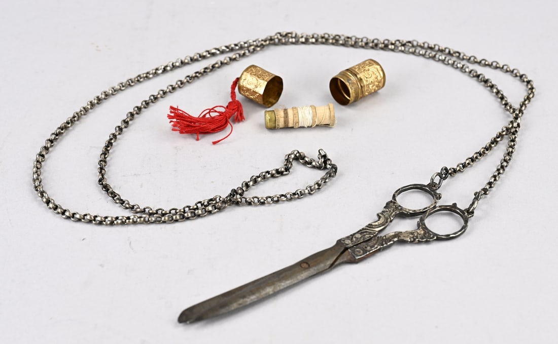 Silver scissors & thread box (double): Fine pair of scissors, 833/000, with silver handles and silver chain. Scissors with ornate handles with engraving. Fitted with a long silver jasseron chain, approx. 135 cm. And a double box with a