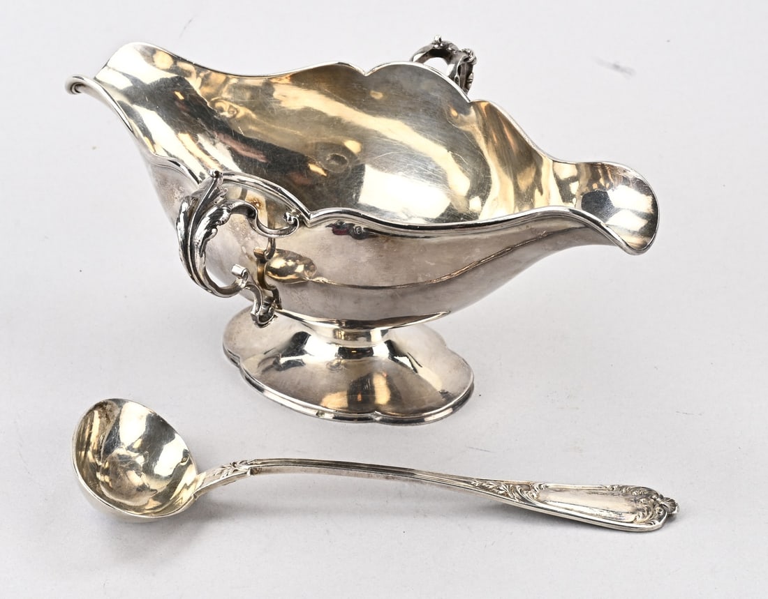 Silver sauce bowl with spoon: Silver sauce boat with spoon, 950/000, oval contoured sauce boat with 2 acanthus leaf handles, on a contoured oval base. MT.: L.Champenois, Paris, 1894-1899. And a matching spoon with an oval bowl