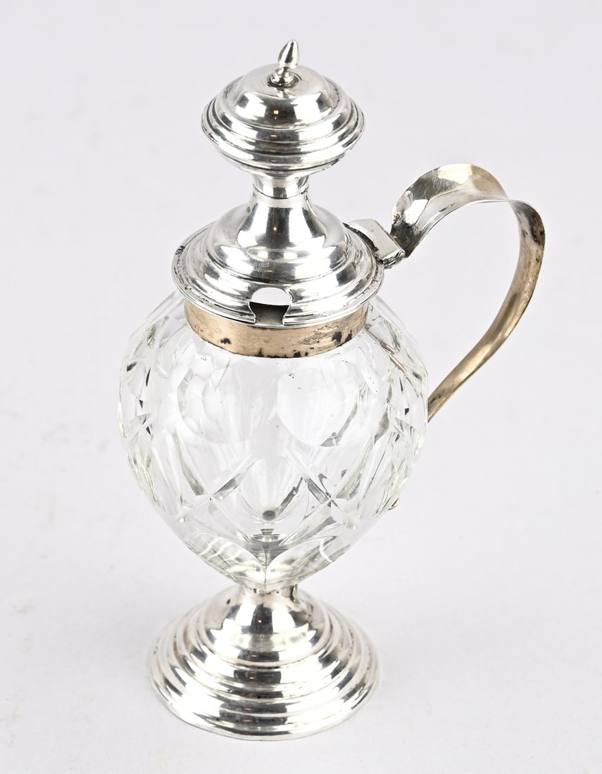 Mustard pot with silverware: Crystal mustard pot on a silver base, silver collar, lid, and handle. 11x8x18cm. MT.: A. de Rooij, 's Hertogenbosch, 1868-1887. Composite. Base slightly dented, otherwise in good condition.