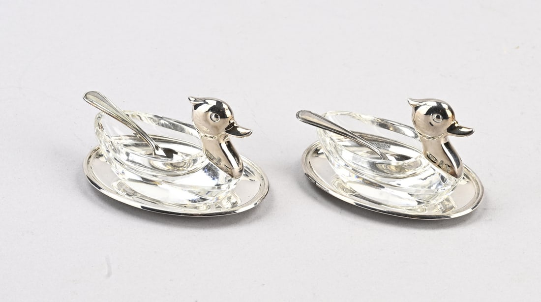 2 Silver swan salt cellars: Two small silver salt cellars, 835/000. Oval silver tray containing a crystal bowl in the shape of a swan with a silver head. And a small silver spoon. Trays and spoons total approx. 36 grams.