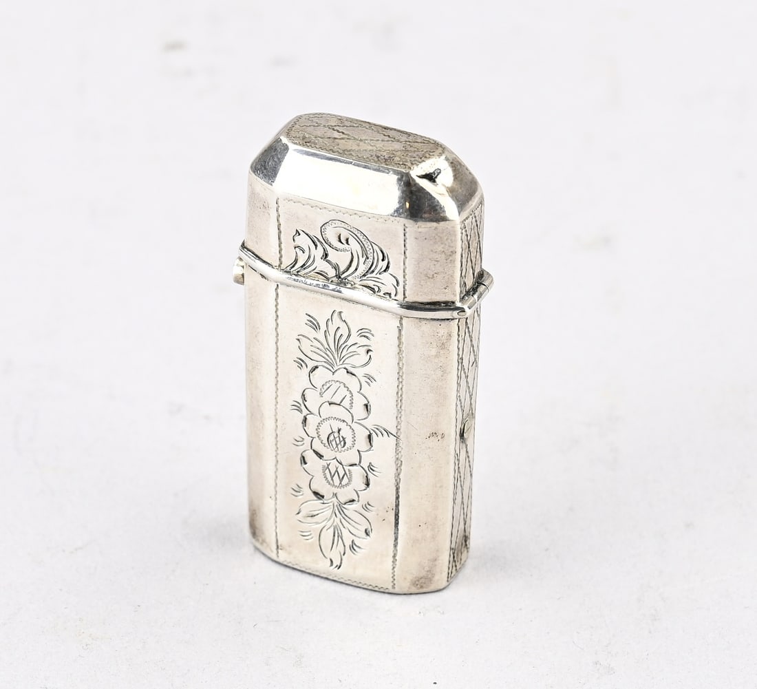 Silver match holder: Silver vesta, 833/000, rectangular contoured model with hinged lid and decorated with engraving. 58x12x28mm. Slightly dented. Approx. 22.3 grams. In reasonably good condition.