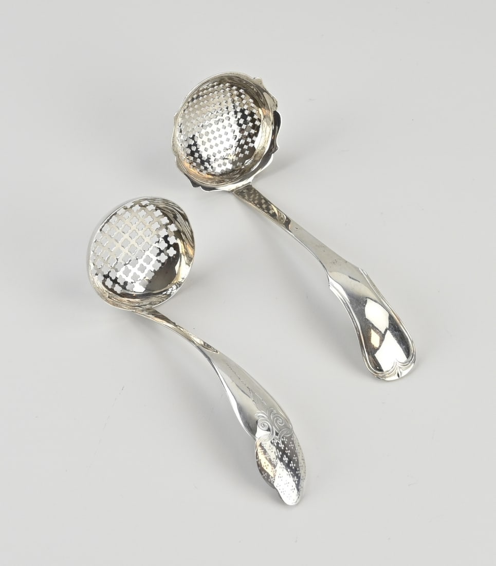 2 Silver sugar spoons: Two silver sugar spoons, 833/000, with round bowls. One spoon features a contoured handle with engraving, MT.: G. van der Dussen, Schoonhoven, 1868. And a spoon with a contoured handle with a