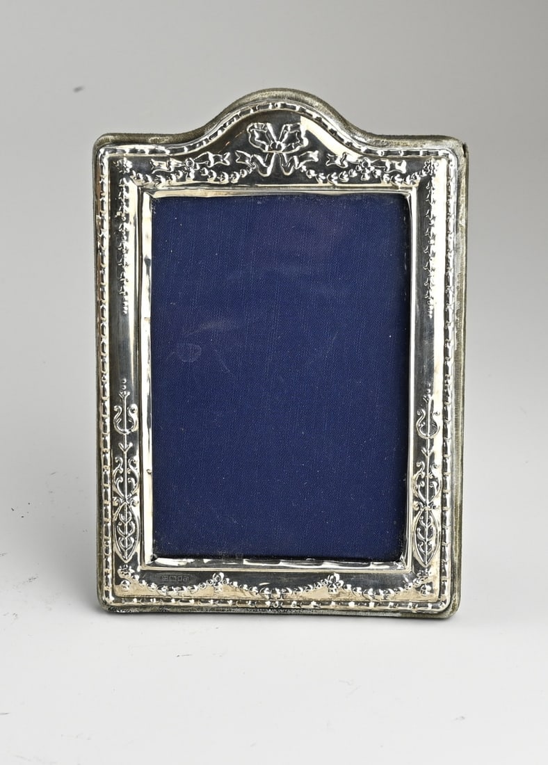 Silver photo frame: Photo frame with blue velvet and a silver element on the front, 925/000, with garland detailing and bows. 11x16cm. London, 1993. In reasonable condition.