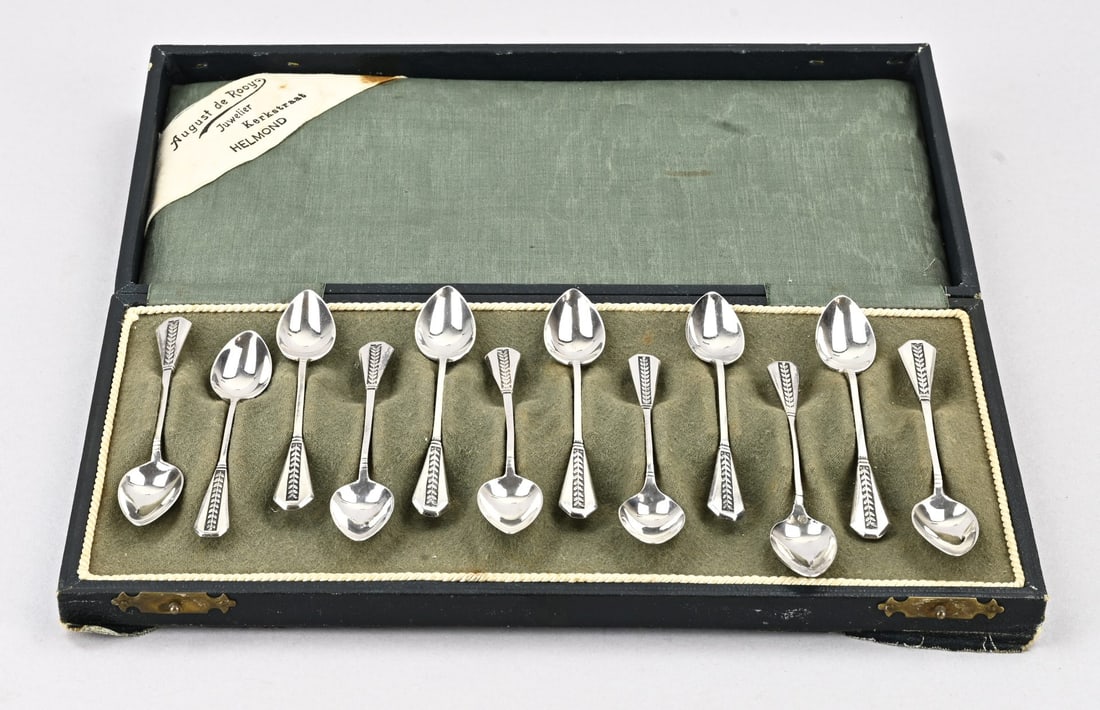 Cassette with 12 silver spoons: Cassette with 12 silver spoons, Art Deco with vertical leaf decoration. Maker: Begeer, Utrecht. 9.5 cm. 78 grams. In very good condition.
