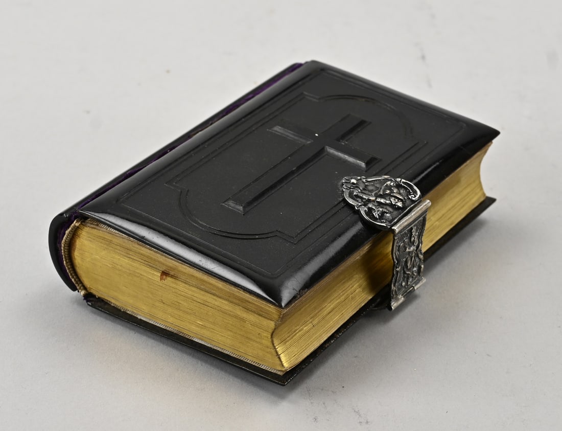 Book with silver lock: Book: The Spiritual Grain of Sand, with a black hardcover featuring a cross and a silver clasp with figures. MT.: J. de Vaal, Schoonhoven, after 1958. 8x11.5x3cm. In good condition.